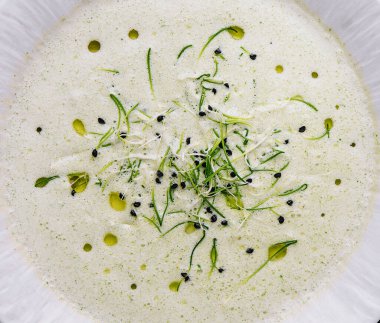 Champignon mushroom cream soup in white plate with pastry