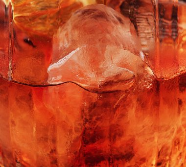 Bardakta koyu turuncu içecek.