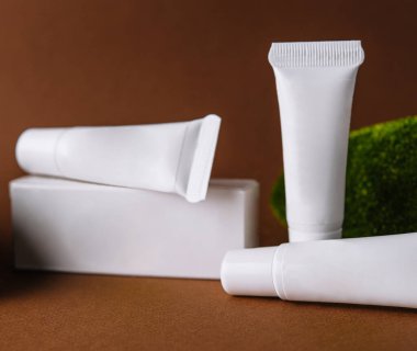 Moisturizer cream white tubes among natural green moss