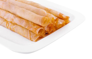 Tasty thin pancake rolls on white plate