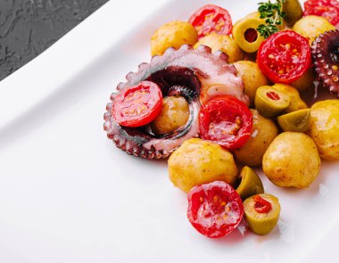 Fresh octopus salad with potatoes and olives on plate