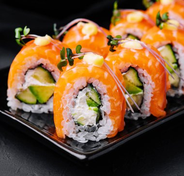 Siyah tabakta avokadosu olan Philadelphia Sushi.