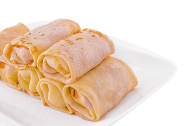 Rolls of pancakes on white plate