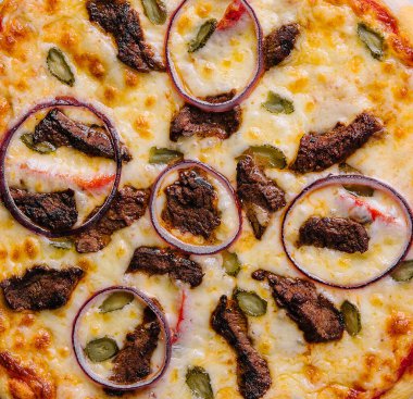 italian pizza with tomatoes, cheese, onions on black