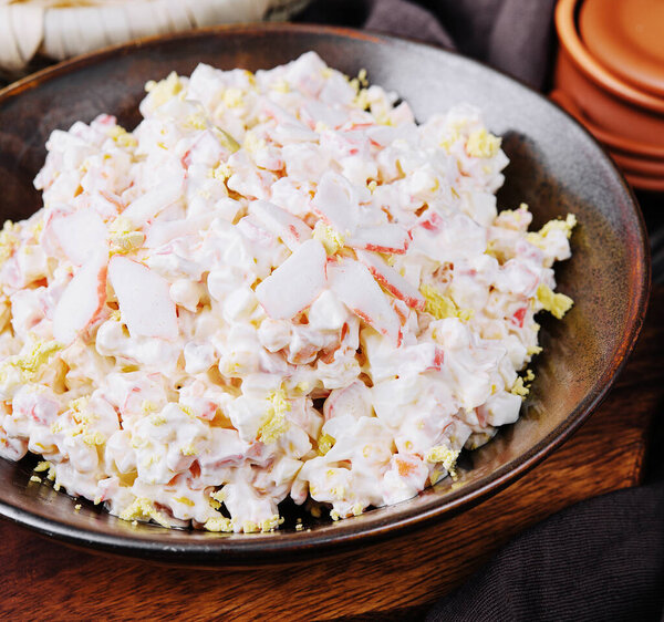 Salad with corn, crab sticks, cucumbers, eggs and mayonnaise