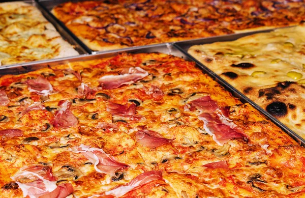 stock image Delicious and unusual large pizzas with mushrooms and cheese, made on two metal trays.