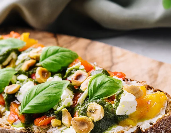 bruschetta with pesto, hazelnuts, cheese and basil