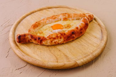 Peynir ve yumurta sarısı ile kaplı Ajarian Khachapuri.