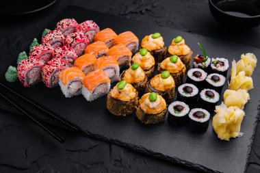 Suşi siyah tahta üst görünümünde ayarlandı