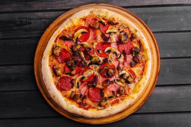 Ahşap arka planda sosisli Pepperoni pizza.