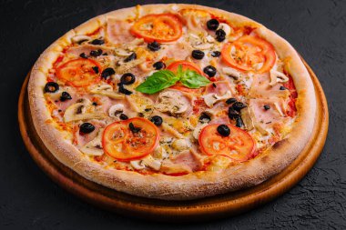 Siyah taşın üzerinde jambonlu ve mantarlı pizza.