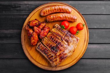 Tavuklu domuz kaburgası ve ahşap tahtada sosis.