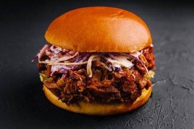 Pulled pork sandwich on black stone clipart