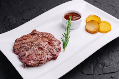 Büyük, sulu biftek ve patates tabağı.