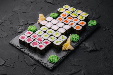 Maki suşi seti siyah taş tepside servis edilir.