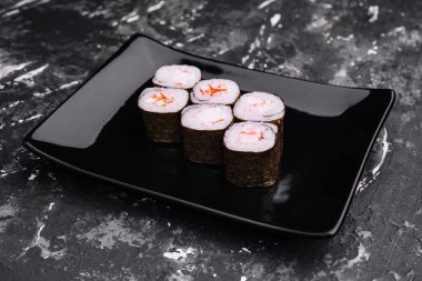 Siyah tabakta karidesli suşi rulo maki.