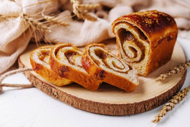 Tahtada elma reçeli ile dilimlenmiş büyük çörek.