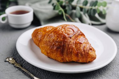 Bir fincan çay ile birlikte kruvasan.