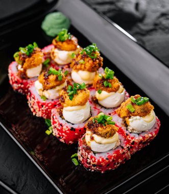 Japon yemeği. Siyah tabakta suşi yuvarlanıyor.