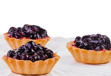 Beyaz büyük tabakta üzümlü küçük kekler.