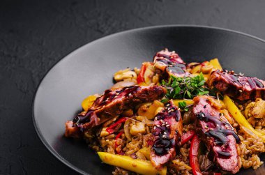 Siyah tabakta sığır etli Çin pilavı.