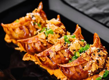 Siyah tabakta Gyoza usulü kızarmış börek.