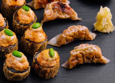 Gyoza veya hamur tatlısı ve sıcak suşi manzarası.