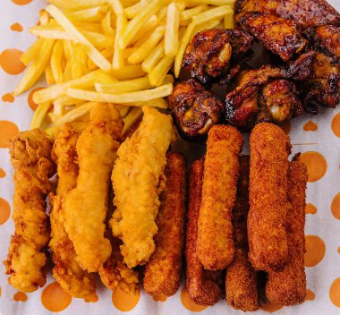 Kızarmış nugget ve baharatlı tavuk bacağı, kanat ve patates kızartması.