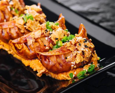 Siyah tabakta Gyoza usulü kızarmış börek.