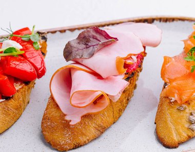 Jambon, biber ve somon ile çeşitli bruschetalar.