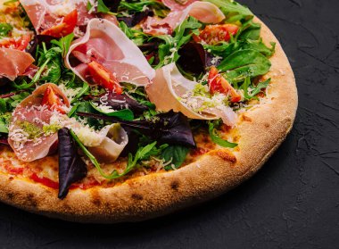 Prosciutto, roka ve parmesanlı pizza.