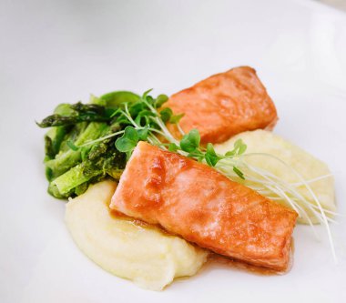 salmon steaks with mashed potatoes on white plate