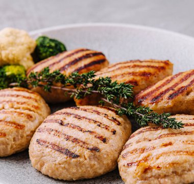 Beyaz tabakta brokoli olan köfteler.