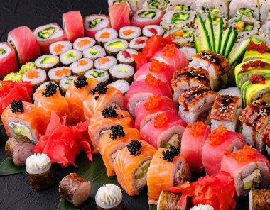 Büyük suşi seti, siyah arka planda tepeden çekilmiş.