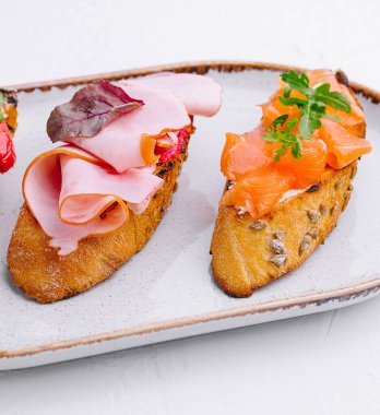 Jambon, biber ve somon ile çeşitli bruschetalar.