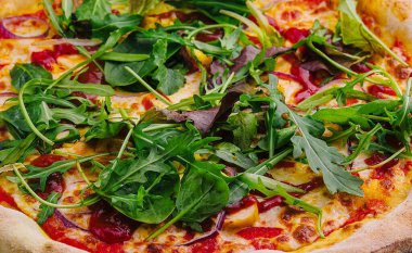 Arkaplanda roka olan pizza.