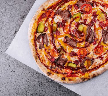 Italian pizza with sausage, meat and cucumbers