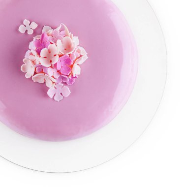 Çiçeklerle süslenmiş pembe kremalı pasta.