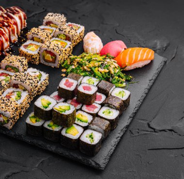 Sushi siyah taş arka planda ayarlandı