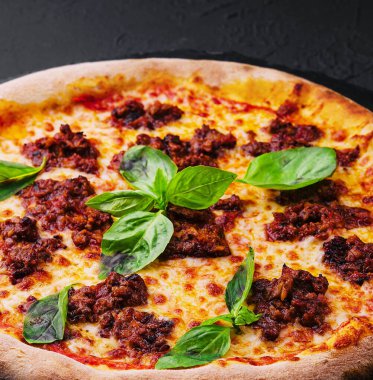 Kıymalı pizza ve taş bir tahtanın üzerinde mozzarella.