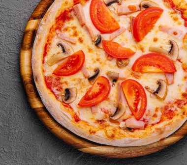 Pizza with ham, tomatoes and mushrooms on top view