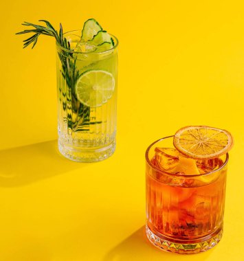 Negroni kokteyli ve sarı arka planda mojito kokteyli.