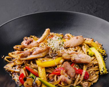 Siyah tabakta sebzeli Çin pilavı.