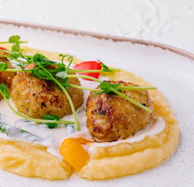 Beyaz tabakta patates püresi ve köfte.