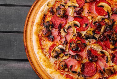 Ahşap arka planda sosisli Pepperoni pizza.