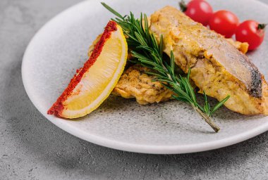 Tabakta ızgara balık bifteği ve sebze