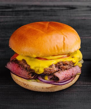 Ahşap masa manzaralı lezzetli bir burger.