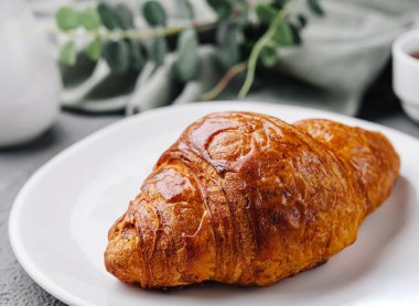 Kruvasan tabakta. Yaklaş.