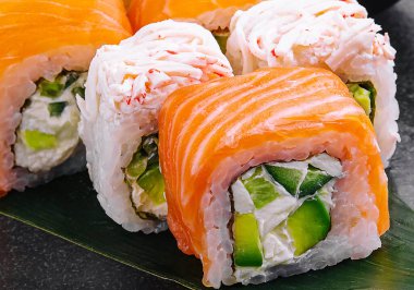 Somon balıklı suşi ve siyah tabakta yengeç.