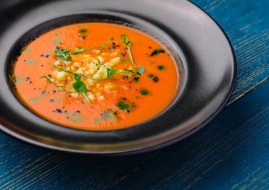 Siyah tabakta domates çorbası.